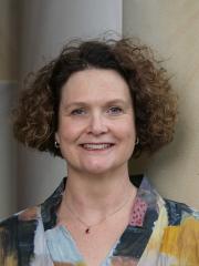 A headshot of Shannon Breen – a white woman with short brown hair standing in the Great Court at UQ
