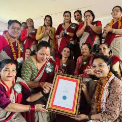 Dr Sanjana Shrestha holding her PhD testamur with friends